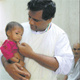 El Padre Ravindra, mano derecha de la Madre Teresa, con un ni&ntilde;o, en el dispensario m&eacute;dico.