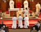 The three deacons kneel before the altar during the ceremony.