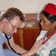 Dr. Brezinski helping a patient with his medical skill and his Catholic faith.