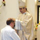 Archbishop Eterovic lays his hands on Nikola Derpich